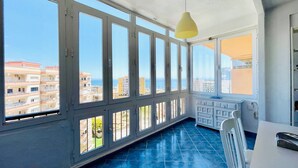 A room with large windows, a blue tiled floor, and a white ceiling.