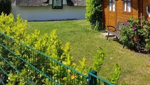 Una casa tradicional con techo de paja y una pequeña construcción de madera cerca.