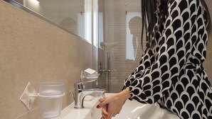Un baño con lavabo, grifo y espejo.