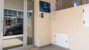 Entrada de hotel con puerta de vidrio, un letrero que dice Landlord Accommodation y una cámara de seguridad.