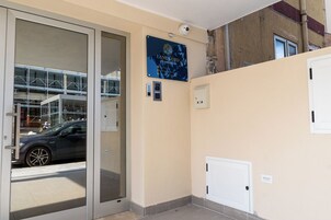 L'ingresso di un hotel con una porta in vetro, una insegna con scritto 'Landlord Accommodation' e una telecamera di sicurezza.