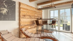 A room with wooden log walls, a glass door leading outside, and a table with chairs. - Luxury Chalet With Private Sauna in Uttendorf (Uttendorf)