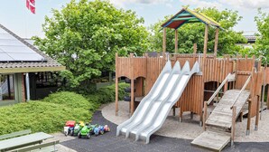A playground with a slide, climbing area, and a picnic table with toy vehicles. - 6 Person Holiday Park Home in Hanstholm (Hanstholm)