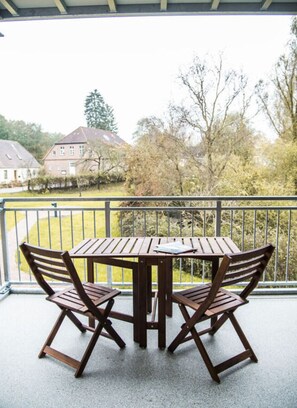 Guests can enjoy a balcony with a table and chairs overlooking a residential area.