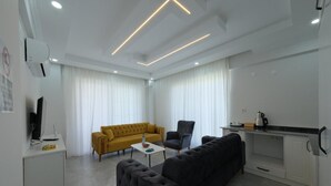 A modern living room with a sofa, armchair, and a coffee table. - The Dalaman Suites & Pension Dalaman Airport 10 km (Dalaman)