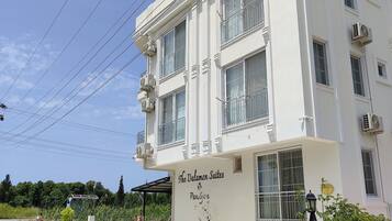 Ein weißes Gebäude mit Balkonen und einem Schild mit der Aufschrift 'The Dalaman Suites Paris'.