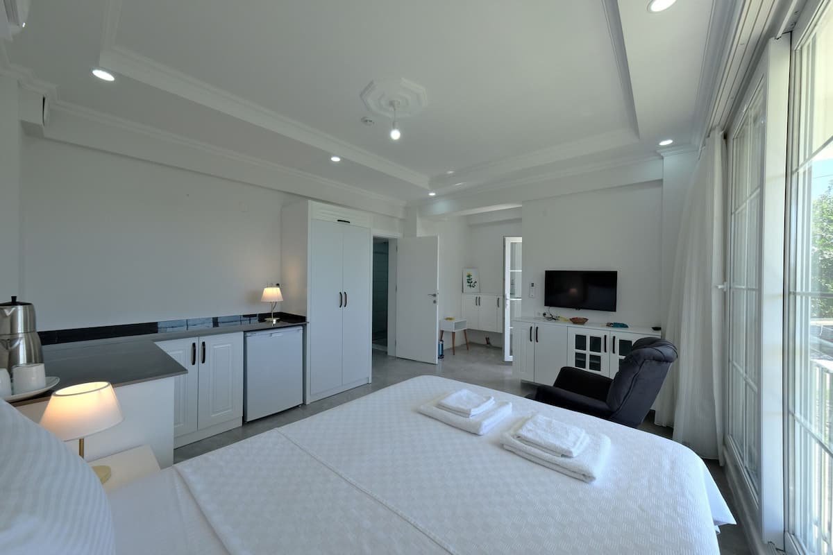 Een moderne hotelkamer met een groot bed, een bureau en een televisie.