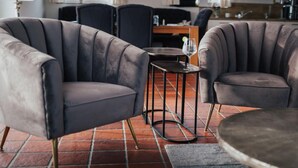 A modern living room with a sofa set, a coffee table, and a dining area in the background. - Villa Jonny am Deich (Dornum)