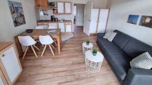 A compact living space with a kitchenette, dining area, and seating area. - In the Villa Granitz (Göhren)