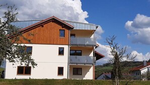 A multi-story building with a wooden facade and balconies.
