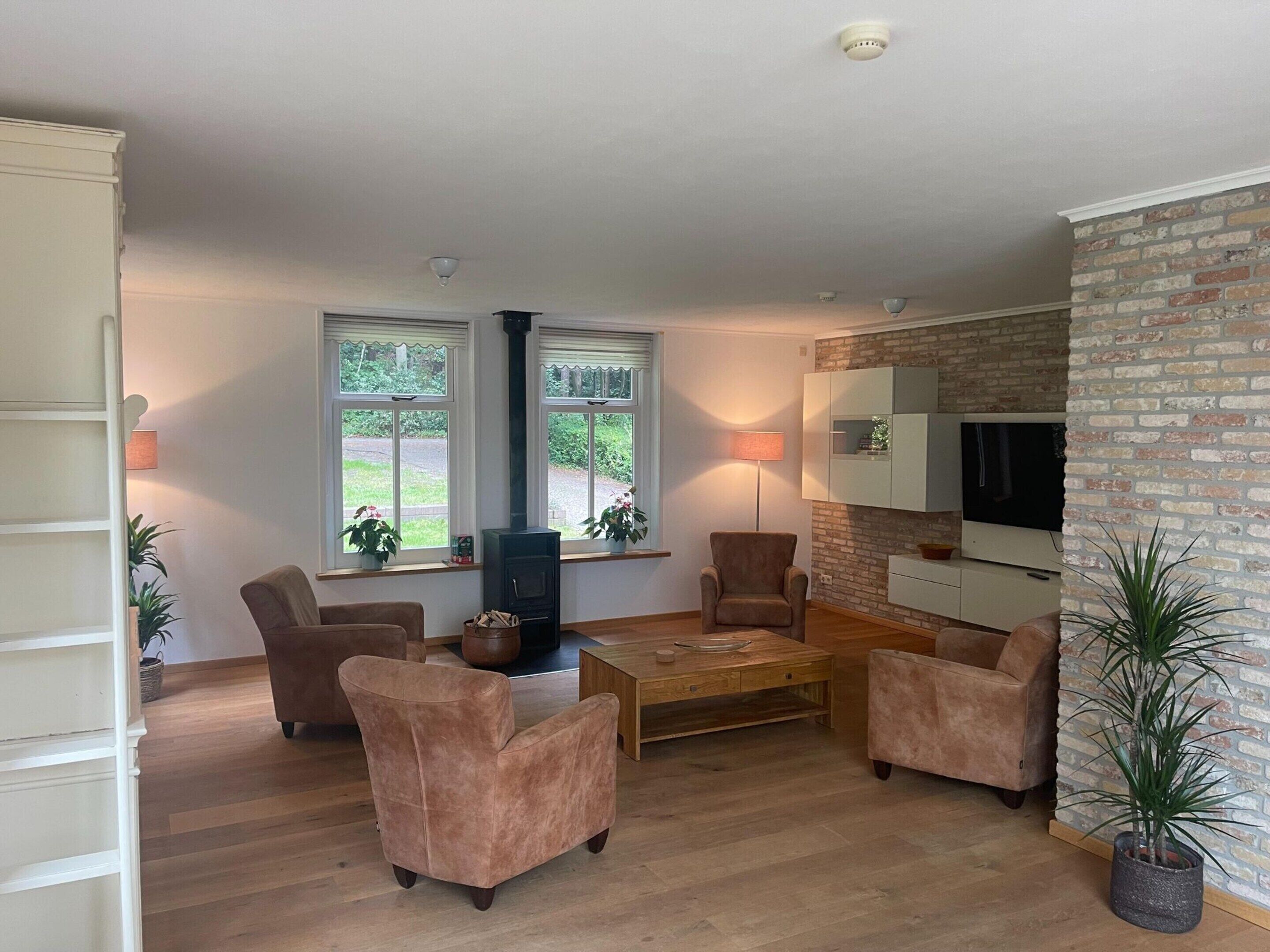 A modern living room with a fireplace, two sofas, a coffee table, and a TV.