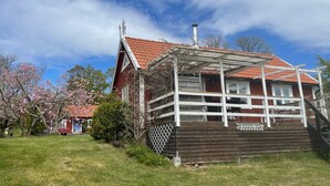 Een houten huis met een rode pannendak en een wit balkon.
