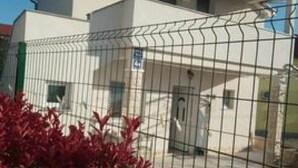 A white building with a metal fence in front. - Apartment Mijatovic (Vodice)