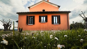 A single-story house with a flat roof, a chimney, and black shutters on the windows. - Holiday Home in Urbania With Garden BBQ (Urbania)