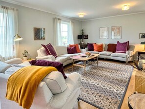 A living room with two sofas, a coffee table, and a patterned rug. - 5 Star Holiday Home in Lottorp (Löttorp)