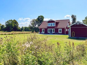 A two-story red house with a large front lawn and a separate garage. - 5 Star Holiday Home in Lottorp (Löttorp)