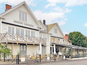 A building with a sign reading 'SANDVIKS HAMNKROG' and outdoor seating with tables and chairs. - 5 Star Holiday Home in Lottorp (Löttorp)