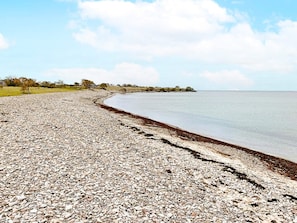 A pebble beach with a calm sea and a clear sky. - 5 Star Holiday Home in Lottorp (Löttorp)
