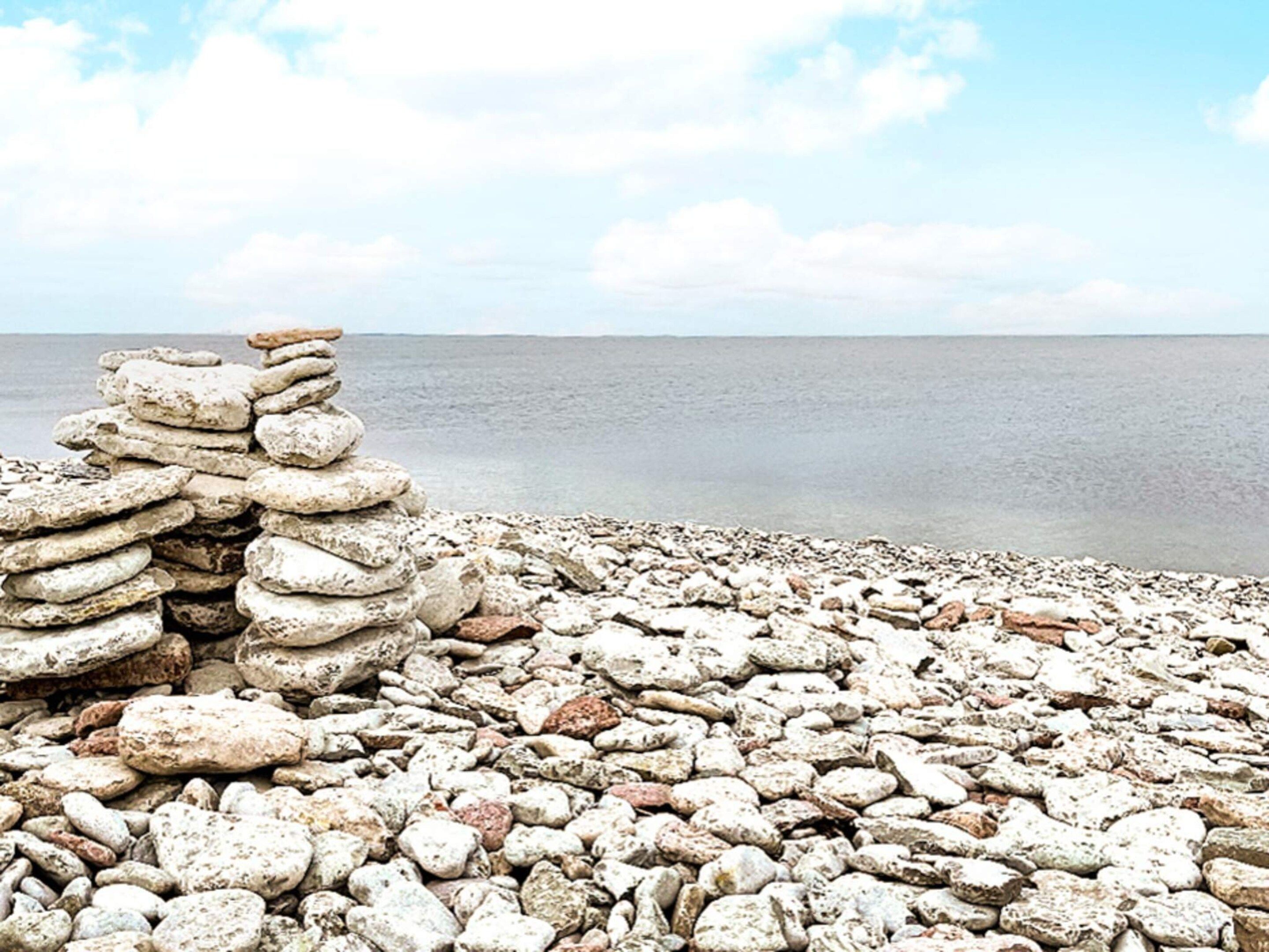 A rocky beach with a stack of stones.