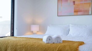A hotel room with a bed, a window, a lamp, and a painting on the wall. - Modern new Homly House at Clyde (Clyde)