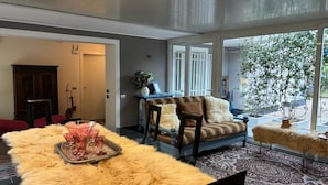 Ein großzügiges Wohnzimmer mit einem großen Fenster, einem Sofa, einem Couchtisch und einem Teppich.