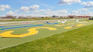 A sports field with multiple lanes and a white fence surrounding it.