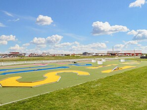 A sports field with multiple lanes and a white fence surrounding it.