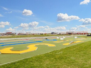 Een sportveld met meerdere banen en een witte omheining.