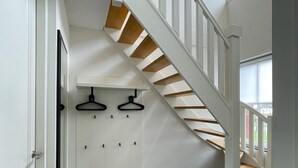 A staircase with white railings and wooden steps leading to an upper floor. - Villa by Tjeukemeer With Sauna & Whirlpool (Delfstrahuizen)