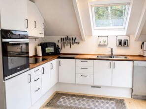 A modern kitchen with white cabinets, a built-in oven, a coffee machine, and a skylight. - 4 Star Holiday Home in Ebeltoft (Ebeltoft)