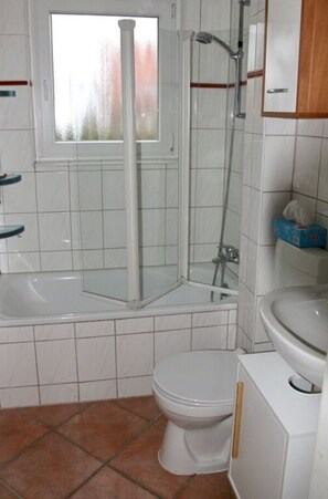A bathroom with a bathtub, a shower, a toilet, and a window. - Picobello I Comfortable Holiday Residence (Timmendorfer Strand)