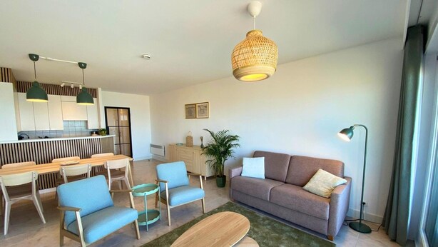 A modern living room with a sofa, chairs, a coffee table, and a dining area with a table and chairs. - Apartment in Nieuwpoort With Sea Views (Nieuwpoort)