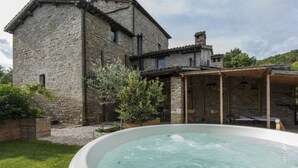 Een stenen gebouw met een hottub op de voorgrond.
