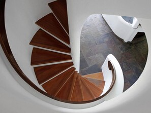 A spiral staircase with wooden steps and white walls. - Hermitage-dahn Modern Retreat (Dahn)