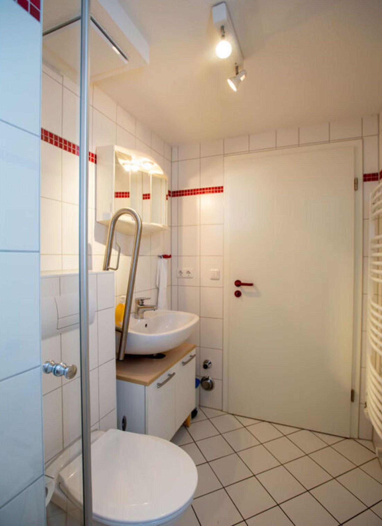 A bathroom with a toilet, sink, and shower area.