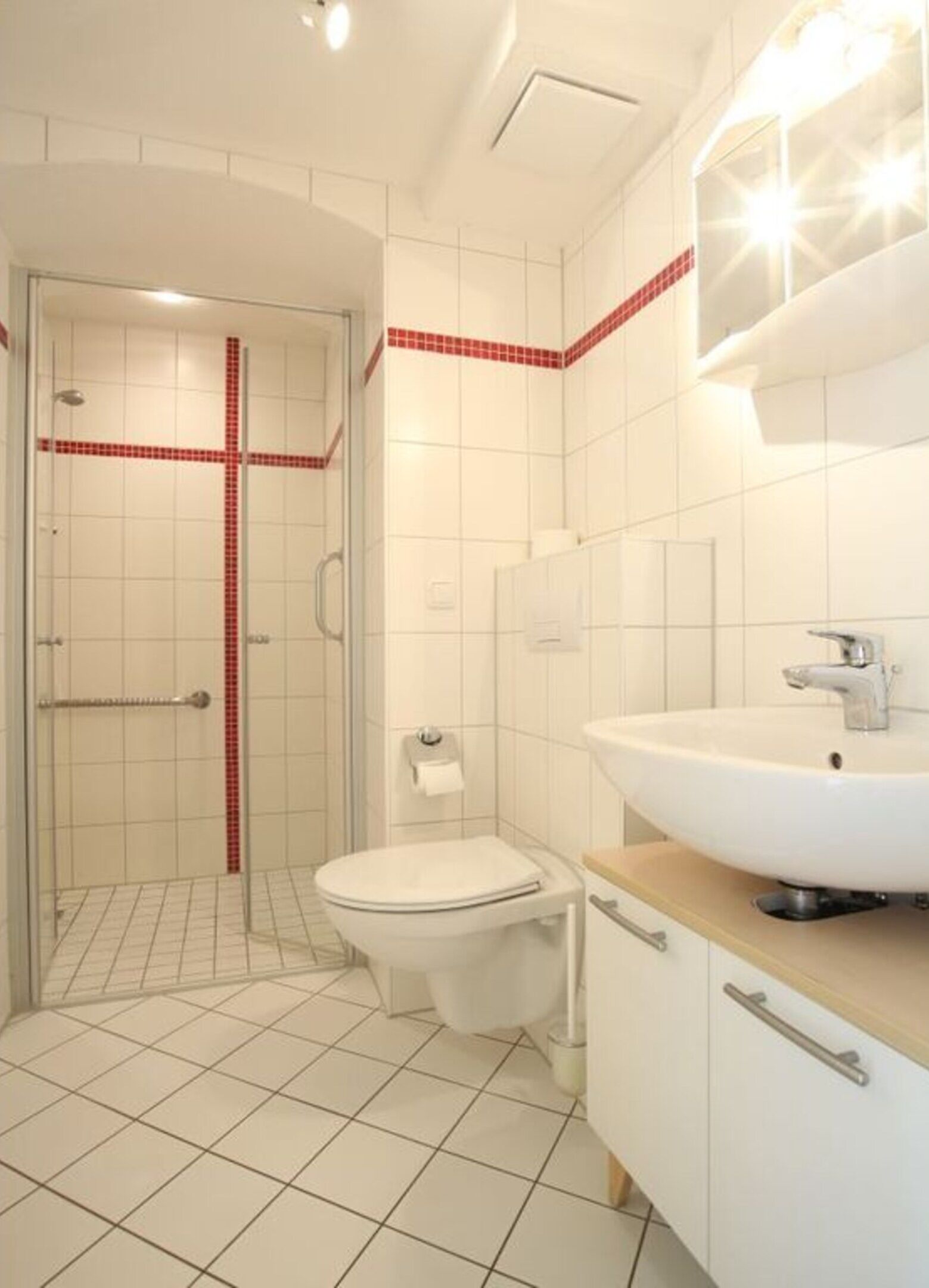 Un bagno moderno con doccia, servizi igienici e lavandino.