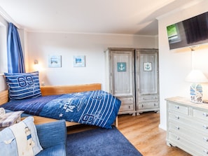 A bedroom with a bed, a dresser, a television, and two wardrobes. - Oostzeevakantie-bork (Kronsgaard)