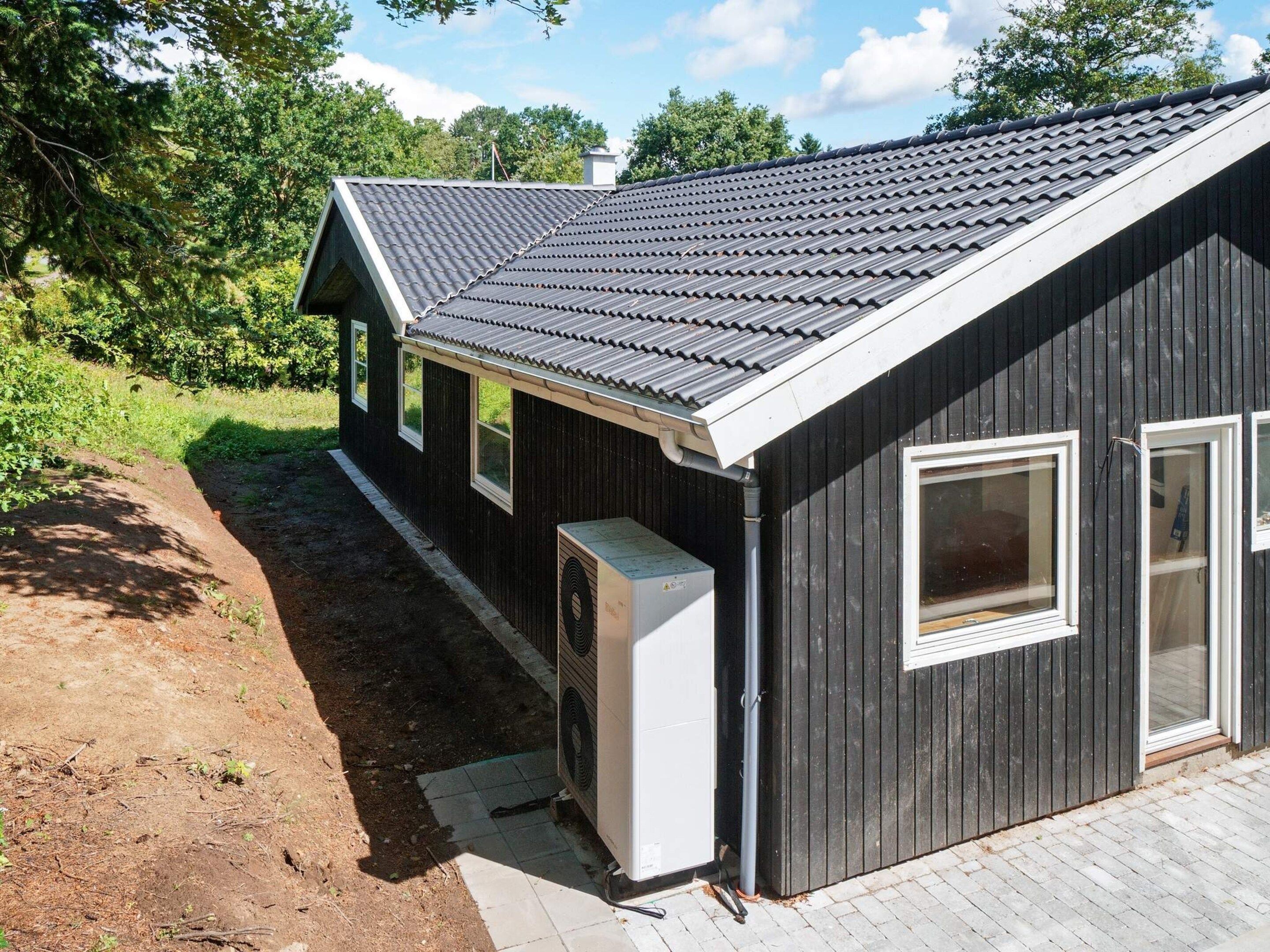 A single-story building with a dark exterior, a sloped roof, and a small attached garage.