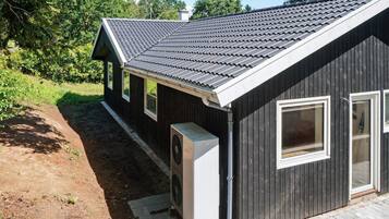 A single-story building with a dark exterior, a sloped roof, and a small attached garage.
