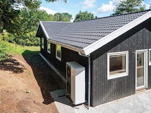A single-story building with a dark exterior, a sloped roof, and a small attached garage.