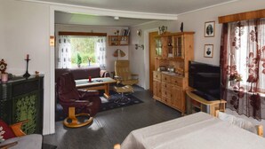 A cozy living room with a sofa, a dining table, a TV, and a cabinet. - 8 Person Holiday Home in Terrak (Bindal)