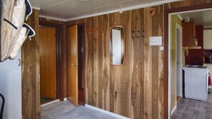 A room with wooden panel walls, a grey tiled floor, a mirror, and a door leading to another room. - 8 Person Holiday Home in Terrak (Bindal)
