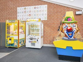 Un bâtiment en briques, avec une rangée de distributeurs automatiques et une grande statue de clown.