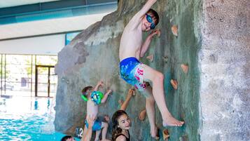 A rock climbing wall with multiple climbers.
