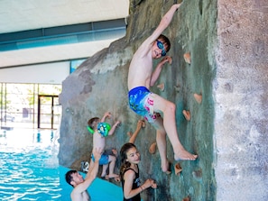 A rock climbing wall with multiple climbers.