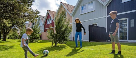 Un barrio residencial con casas, un patio césped y un balón de fútbol.