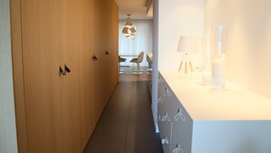 A modern hotel corridor with wooden walls, a white reception desk, and a dining area in the background. - Romantic Coastal Escape (Nieuwpoort)
