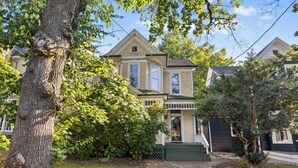 A two-story house with a front porch, a small window, and a door.
