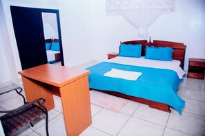 Un dormitorio con una cama, un escritorio y una silla.