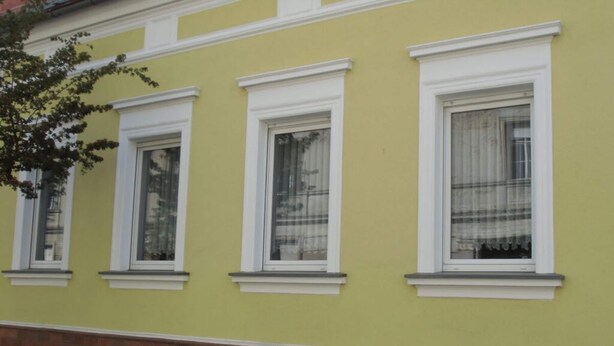 A building with three windows, each with white frames and curtains. - Bille Comfortable Holiday Residence (Luckenwalde)